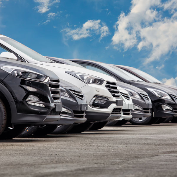 row of cars parked below blue sky